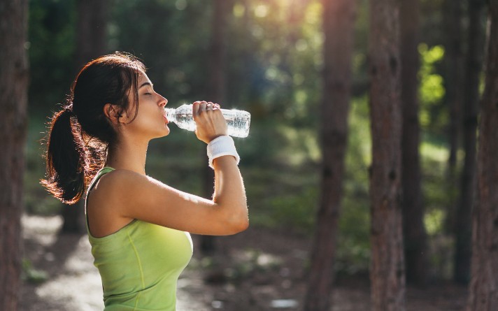 woman drinking water outside