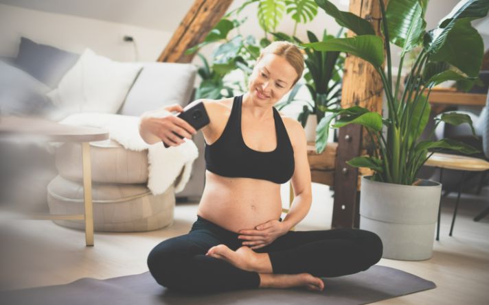 woman taking a photo of herself while working out  after pregnancy.