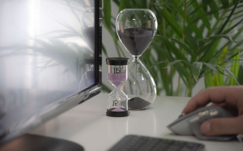 limiting your screen time signified by an egg timer and someone using a mouse